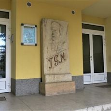 Masarykův pomník u vchodu do školy ve Velkém Oseku