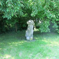 Kamenná plastika Torzo ženy na rozcestí u hřiště v Radonicích