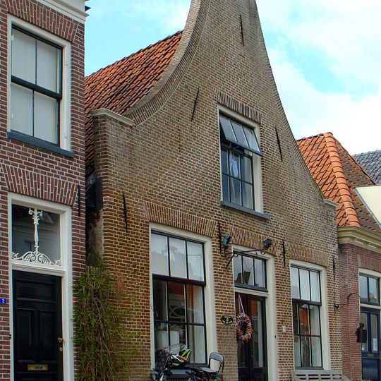 Huis met ingezwenkte halsgevel met halfronde zandstenen topafdekking