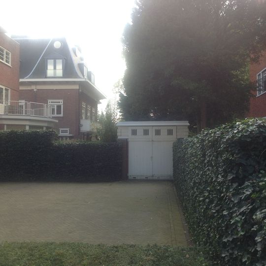 Garage in rode baksteen op rechthoekig grondplan en gedekt door een plat dak