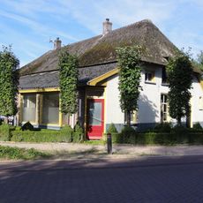 Gepleisterde boerderij onder met riet en pannen gedekt wolfdak