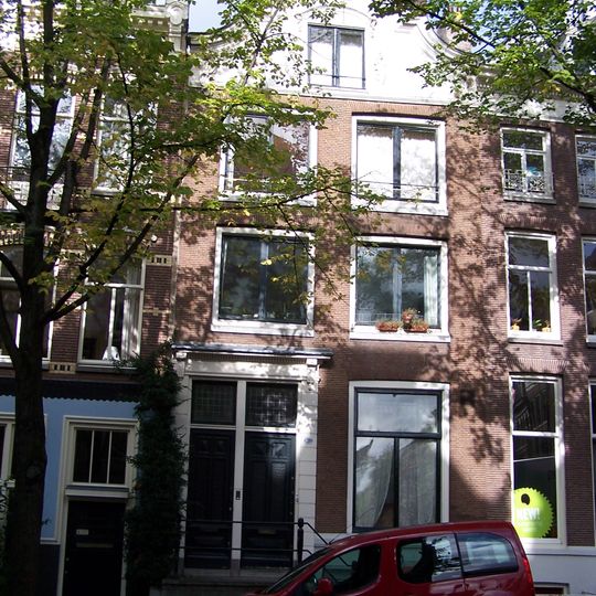 Pand met gevel onder houten in- en uitgezwenkte top met hoekconsoles en snijwerk om het zoldervenster