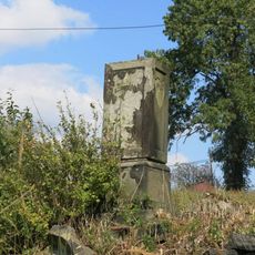 Podstavec s ulomeným křížem v centru Mukařova