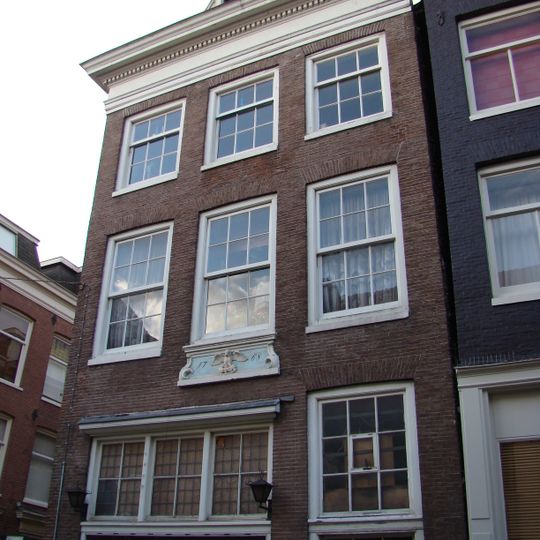 Huis met voorgevel onder rechte lijst waarop een rondbogige dakkapel