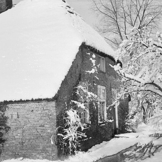 Boerderij met dwarshuis en langsdeel onder rieten wolfdak. Kruiskozijn met onderluiken