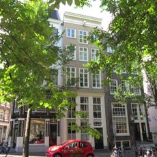 Hoekhuis, halsgevel met gedeelde vleugelstukken en palmet in de afdeling