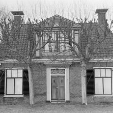 Eenvoudige woning met dakkapel en aangebouwde schuur