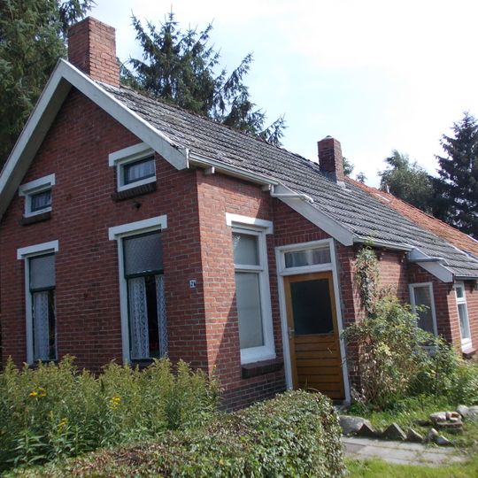 Arbeiderswoning onder driezijdig schilddak met wolfseind tegen rechte voorgevel