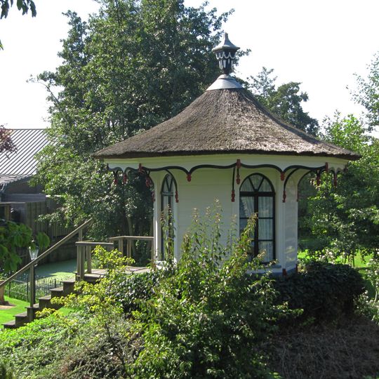 Ahthoekige houten theekoepel in de tuin van dit pand, Lod. XVI met bewerkte daklijst en als bekroning een siervaas op het dak
