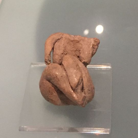 Seated figurine with legs tucked to the right