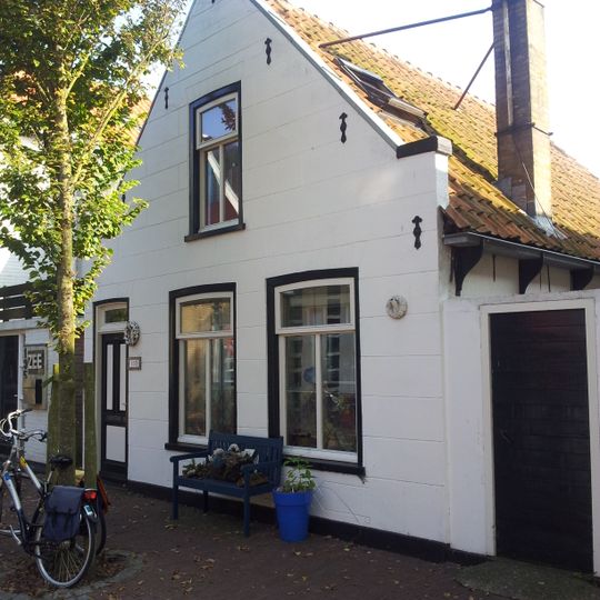 Pand onder zadeldak tegen afgeknotte gepleisterde topgevel