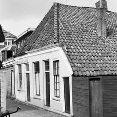 Kleine stadswoning. Gepleisterde voorgevel met lage goot. Schilddak met pannen. Achtergevel aan de Gotte met houten topgevel en vakwerk. (Genaamd wevershuisje)