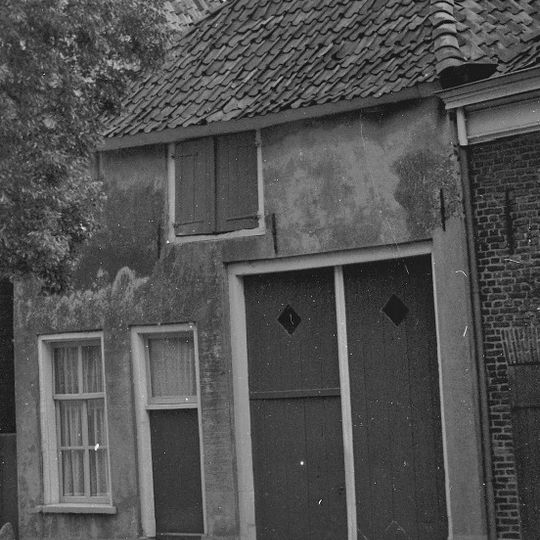 Huis onder schilddak met gepleisterde voorgevel en zijgevel