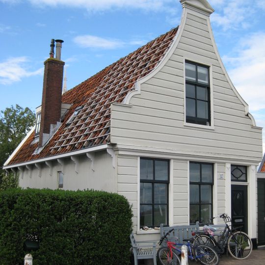 Houten huis. Uit- en ingezwenkt voorschot . Goede pui; empire deur en bovenlicht in omlijsting; gepotdekselde rechterzijwand