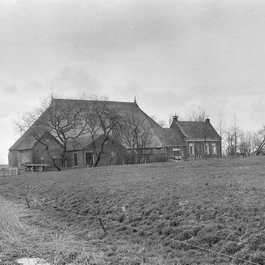 Kop-hals-rompboerderij met voorhuis onder zadeldak tegen topgevel met in de top tweelichtskozijnen en roeden in de overige vensters