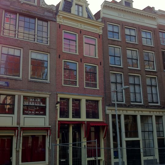 Huis waarvan de gevel bestaat uit een houten pui en een bovenstuk onder rechte lijst met consoles