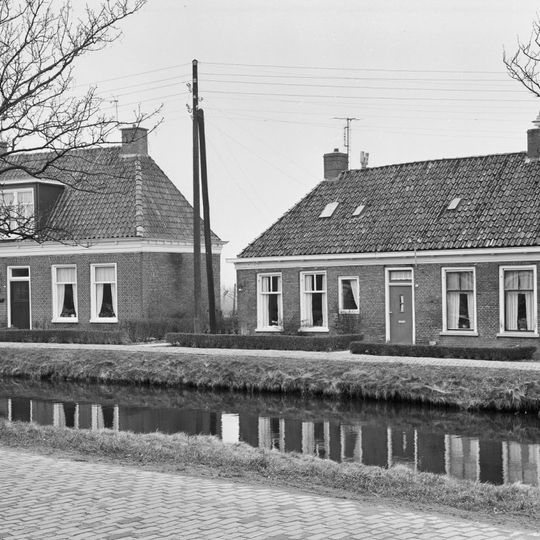 Pand met voorgoot op klosjes onder schilddak met hoekschoorstenen