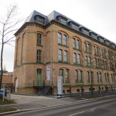 Fabrikkomplex mit dreigeschossigem Kopfbau und dem gleichzeitig errichteten Teil der rückwärtig anschließenden eingeschossigen Oberlichthalle Waldenburger Straße 63