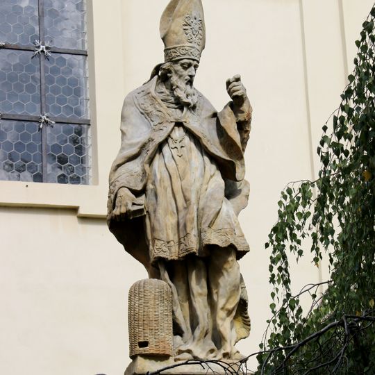 Socha svatého Ambrože na ohradní zdi kostela v Lysé nad Labem