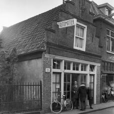 Pand met eenvoudige geheel bakstenen trapgevel met lijsten