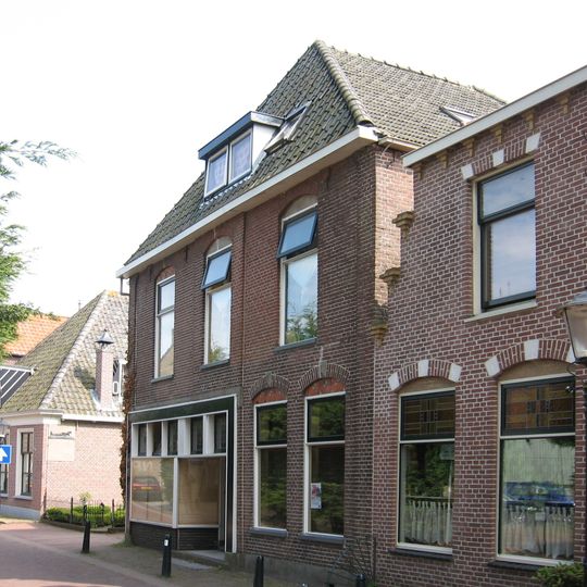 Gaaf breed pand onder tentdak met bewerkte deur