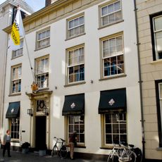 Huis met geblokt gepleisterde gevel en kroonlijst met triglyphen