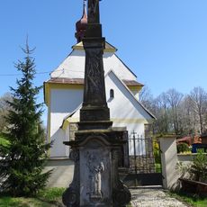 Kříž v Helvíkově před kaplí Nanebevzetí Panny Marie