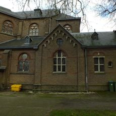 Eenlaags tussenruimte, vijf traveeën lang en drie breed en heeft een vergelijkbare detaillering als de kerk