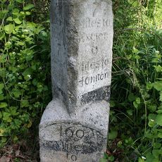 Milestone, 80m W of turn to Farlands Farm, opp. Gribble Lane