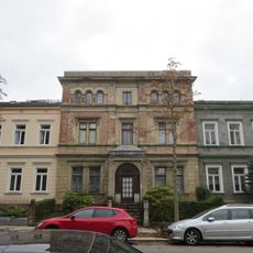 Mietshaus in geschlossener Bebauung mit Vorgarten und Einfriedung; Heinrich-Beck-Straße 27