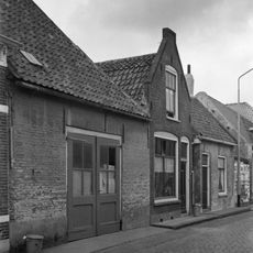 Eenvoudig huisje met geverfde langsgevel aan de straat