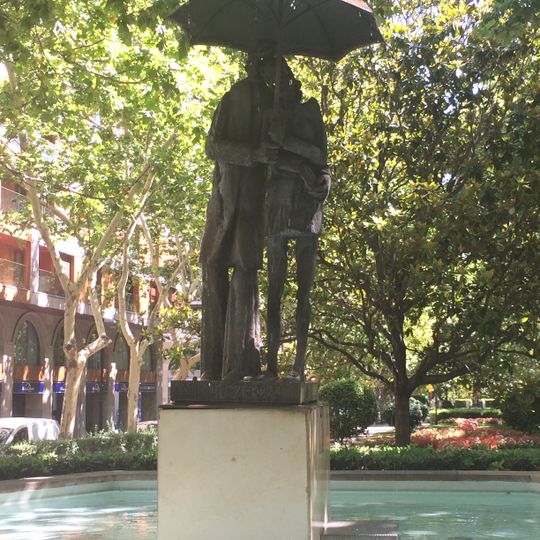 Pareja paseando bajo un paraguas