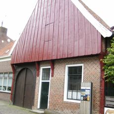 Saksische hoeve met stijl- en regelwerk en hoge houten puntgevel met gesneden topmakelaar. Thans in gebruik als Grols Museum