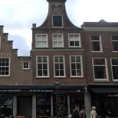 Pand met klokgevel met horizontale banden, bekroond door driehoekig fronton met vazen op de hoeken