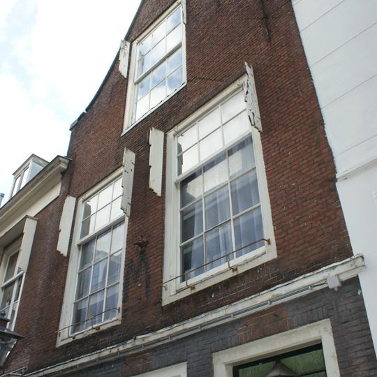 Pand met tuitgevel met aanzetsteen. Bovenvenster oorspronkelijk