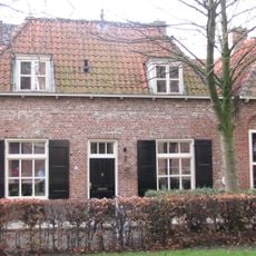 Huis met gewit lijstgeveltje met muurankers