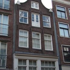 Huis met gevel onder klokvormige top met rollagen