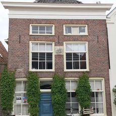 Pand met later verhoogde voorgevel met gevelsteen onder zadeldak