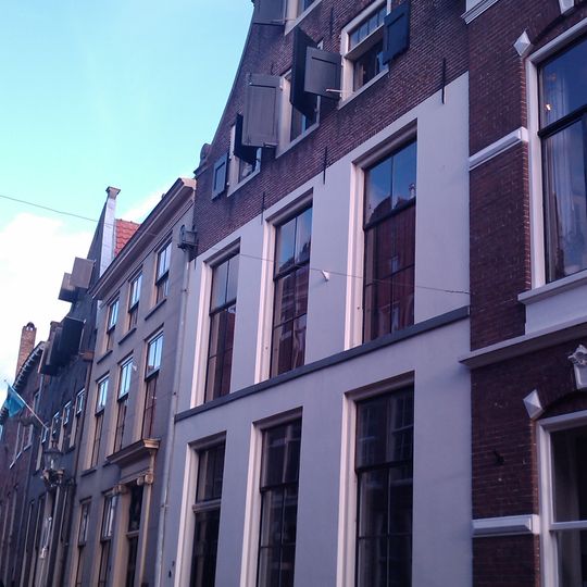 Onderkelderd huis met door natuursteen gedekte klokgevel voorzien van aanzetvoluten