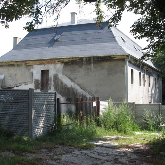 Dawny dwór z XVIII wieku o cechach późnobarokowych, murowany z kamienia łamanego tynkowany