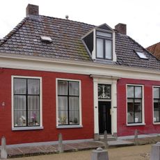 Linkerhelft van woonhuis onder schilddak en hoekschoorstenen