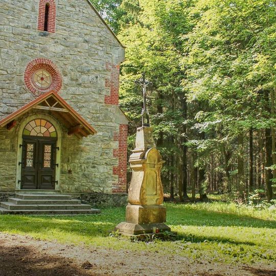 Kříž ve Vysokém Potoku před kaplí v lese