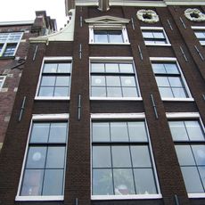 Huis uit 1642/43, verenigd achter een gezamenlijke lisenengevel met de nrs 153, 155
