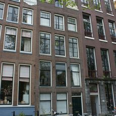 Pand met rijk gebeeldhouwde halsgevel met deurpartij