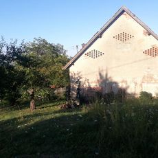 Kříž u zdi domu ve Vrážném