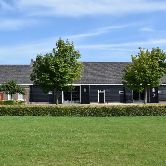 Boerderij met woning en schuur aaneen, rond 1915 gebouwd in streek-eigen bouwtrant