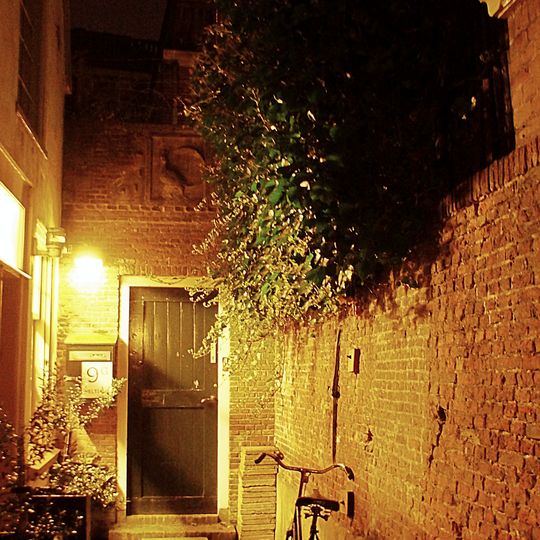 Poortje met gevelsteen waarop een pauw, en omlijsting