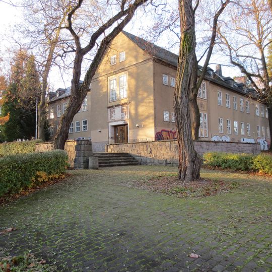 Schule mit gestalteter Grünfläche vor der Schule, Einfriedungsmauern und Stützmauern Weststraße 19