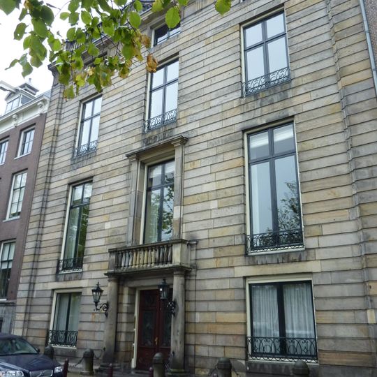 Dubbel huis met monumentale geslaagde zandstenen drie vensters brede gevel onder triglyfenlijst waarop gebeeldhouwde balustrade.