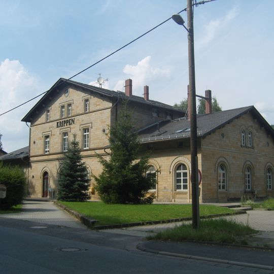 Empfangsgebäude mit Bahnsteigüberdachung und überdachter Abgang mit Wartehäuschen, dazu Brunnen und zwei durch Mauern mit dem Empfangsgebäude verbundene Nebengebäude Friedrich-Gottlob-Keller-Straße 7